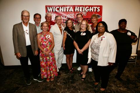 Classmates gather in front of the “Wichita Heights Class of 76” reunion banner